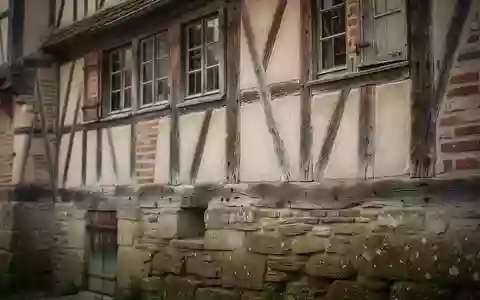 Fassade eines historischen Fachwerkhauses mit traditionellem Mauerwerk und Steinunterbau bei natürlichem Tageslicht - Foto: über boerse-global.de
