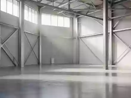 Ein minimalistischer Industrieraum mit poliertem Betonboden und natürlichem Lichteinfall durch hohe Fenster. - Foto: über boerse-global.de