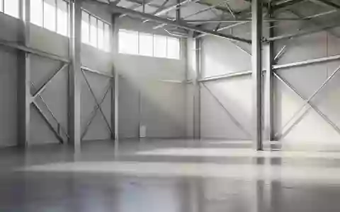 Ein minimalistischer Industrieraum mit poliertem Betonboden und natürlichem Lichteinfall durch hohe Fenster. - Foto: über boerse-global.de