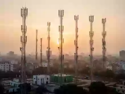 Mobilfunkmasten vor einem dunstigen Abendhimmel in einer indischen Großstadt - Foto: über boerse-global.de
