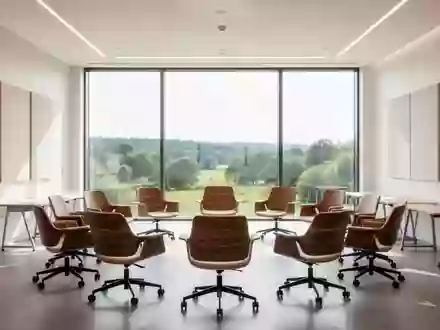 Ein heller, moderner Konferenzraum mit ergonomischen Stühlen in einer kreisförmigen Anordnung vor einer Fensterfront. - Foto: über boerse-global.de