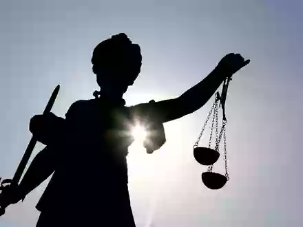 Die Göttin Justitia im Gegenlicht auf dem Gerechtigkeitsbrunnen in Frankfurt am Main. (Symbolbild) - Foto: Arne Dedert/dpa