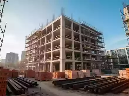 Eine Baustelle mit einem im Bau befindlichen Wohngebäude aus Stahlbeton in einem städtischen Umfeld. - Foto: über boerse-global.de
