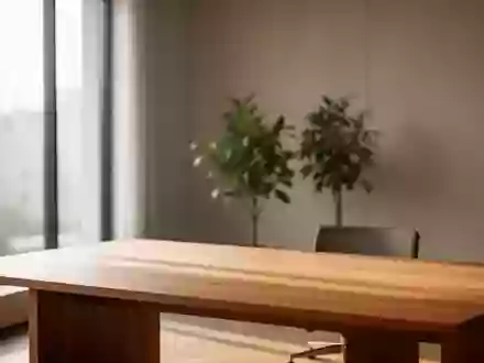 Ein minimalistischer, leerer Büroarbeitsplatz mit einfallendem Tageslicht und einer Pflanze vor einer neutralen Wand. - Foto: über boerse-global.de