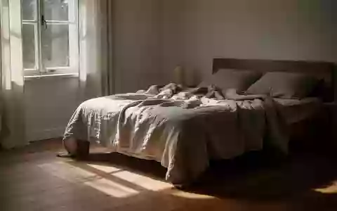 Ein sonnendurchflutetes Schlafzimmer mit einem ungemachten Bett in einer ruhigen, minimalistischen Umgebung. - Foto: über boerse-global.de