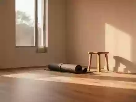 Ein minimalistisch eingerichteter, sonnendurchfluteter Yogaraum mit Holzboden und einer zusammengerollten Yogamatte. - Foto: über boerse-global.de
