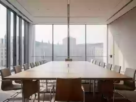 Ein heller, leerer Konferenzraum in einem modernen Regierungsgebäude mit einem großen Holztisch und natürlichem Licht. - Foto: über boerse-global.de