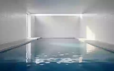 Ein leeres, hell gefliestes Schwimmbecken in einer minimalistischen Umgebung bei natürlichem Lichteinfall. - Foto: über boerse-global.de