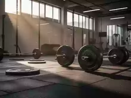 Leerer, minimalistischer Fitnessraum mit Hantelscheiben auf einem dunklen Gummiboden in gedämpftem Tageslicht. - Foto: über boerse-global.de