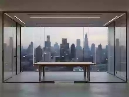 Ein minimalistisches, modernes Büro mit leeren Konferenzräumen und Blick auf die Skyline bei Dämmerung. - Foto: über boerse-global.de