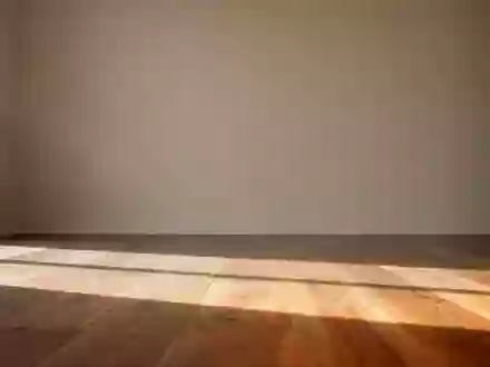 Ein heller, minimalistischer Raum mit einem Holzboden und einer neutralen Wand bei natürlichem Lichteinfall. - Foto: über boerse-global.de