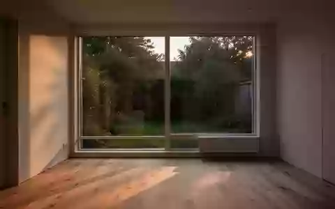 Ein minimalistisches, sonnendurchflutetes Homeoffice bei Tageslicht mit Blick in einen ruhigen Garten. - Foto: über boerse-global.de