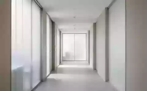 Ein minimalistischer, lichtdurchfluteter Klinikflur mit klaren architektonischen Linien und einer ruhigen Atmosphäre. - Foto: über boerse-global.de