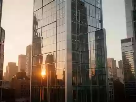 Moderne Glasfassade eines Bürogebäudes in einer urbanen Umgebung bei Sonnenuntergang. - Foto: über boerse-global.de