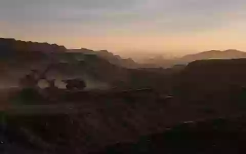 Große Tagebau-Mine bei Sonnenaufgang mit schweren Maschinen in einer weitläufigen Erdausgrabung. - Foto: über boerse-global.de