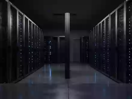 Ein minimalistischer, moderner Serverraum bei Nacht mit in blauem Licht schimmernden Serverracks auf einem polierten Betonboden. - Foto: über boerse-global.de