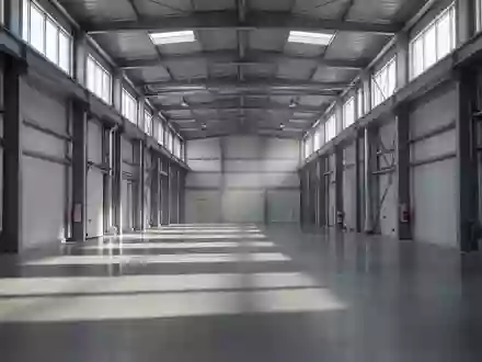 Ein leerer, stiller Industriegang in einer modernen Fertigungshalle mit natürlichem Lichteinfall und langen Schatten. - Foto: über boerse-global.de