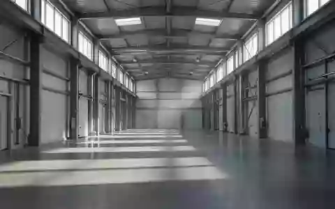 Ein leerer, stiller Industriegang in einer modernen Fertigungshalle mit natürlichem Lichteinfall und langen Schatten. - Foto: über boerse-global.de