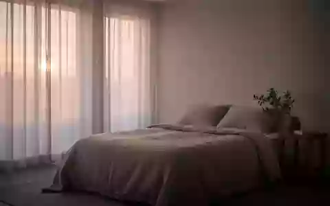 Ein minimalistisch eingerichtetes, ruhiges Schlafzimmer im sanften Morgenlicht. - Foto: über boerse-global.de