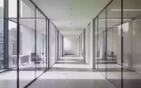 Ein leerer, modern gestalteter Büroflur mit Glaswänden und neutralem Licht, der eine Atmosphäre von Transparenz und Struktur vermittelt. - Foto: über boerse-global.de