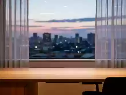 Ein minimalistischer, moderner Arbeitsplatz bei Dämmerung mit Blick auf die Stadt, frei von technischen Geräten. - Foto: über boerse-global.de