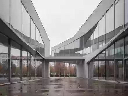 Moderne architektonische Fassade aus Glas und Beton in einer Stadtlandschaft bei bewölktem Himmel. - Foto: über boerse-global.de