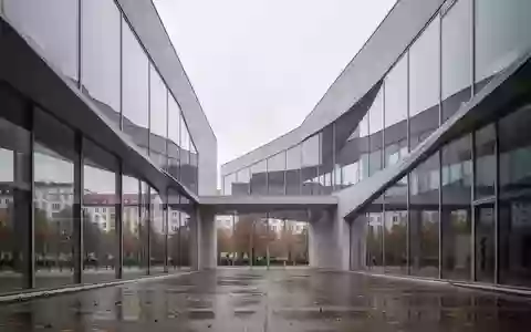 Moderne architektonische Fassade aus Glas und Beton in einer Stadtlandschaft bei bewölktem Himmel. - Foto: über boerse-global.de