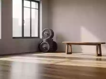 Ein heller, minimalistischer Fitnessraum mit Hantelscheiben und einer Holzbank in natürlichem Morgenlicht. - Foto: über boerse-global.de