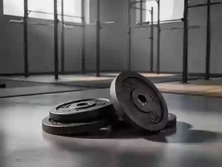 Schweres Hantelscheiben-Set auf einem polierten Betonboden in einem minimalistischen Fitnessraum bei natürlichem Licht. - Foto: über boerse-global.de