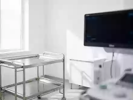 Ein steriler, minimalistischer Behandlungsraum in einer kardiologischen Klinik mit einem leeren medizinischen Gerätewagen. - Foto: über boerse-global.de