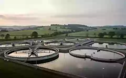 Betonbecken einer KlĂ€ranlage in einer lĂ€ndlichen Umgebung bei Tagesanbruch. - Foto: ĂŒber boerse-global.de