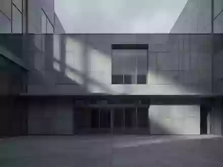 Eine leere, moderne Fassade eines Verwaltungsgebäudes aus Beton und Glas bei bewölktem Himmel. - Foto: über boerse-global.de