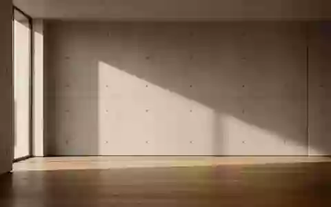 Ein minimalistischer, moderner Innenraum mit weichem Tageslicht und langen Schatten auf einer Betonwand und einem Holzboden. - Foto: über boerse-global.de