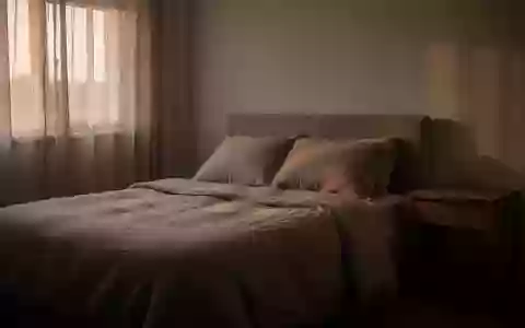 Ein ruhig gestaltetes Schlafzimmer im sanften Licht der Morgendämmerung mit minimalistischer Einrichtung. - Foto: über boerse-global.de