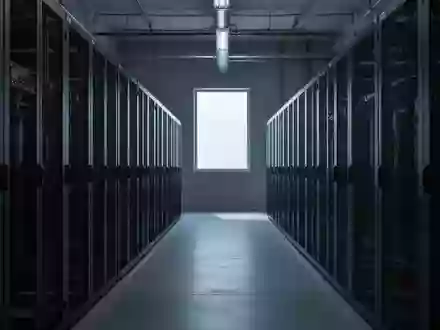 Leere, unbeleuchtete Server-Racks in einem industriellen Rechenzentrum bei gedimmtem Tageslicht. - Foto: über boerse-global.de