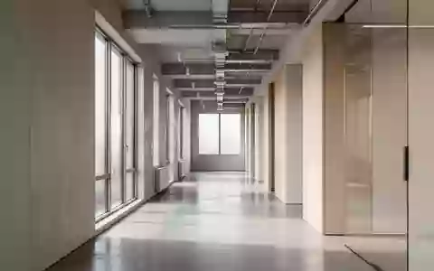 Ein minimalistischer, moderner Büroflur mit natürlichem Lichteinfall und klaren architektonischen Linien ohne Personen. - Foto: über boerse-global.de