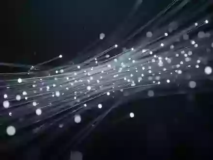 Abstrakte Darstellung von digitalem Schutz durch Lichtpartikel in einer dunklen, technischen Umgebung. - Foto: über boerse-global.de