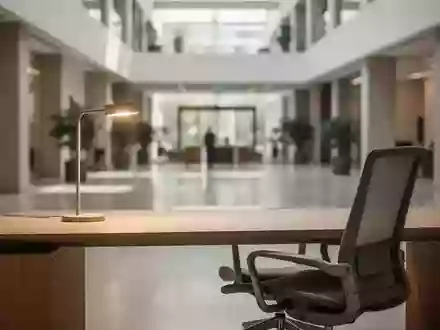 Ein minimalistischer, moderner Büroarbeitsplatz mit einem leeren Schreibtisch und einem ergonomischen Stuhl. - Foto: über boerse-global.de