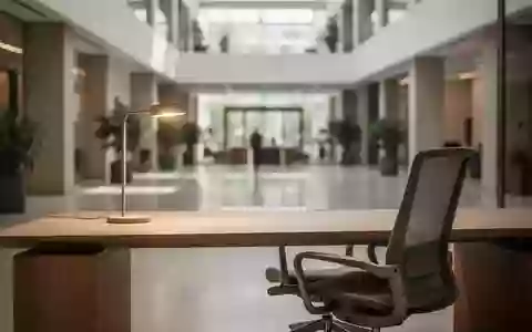 Ein minimalistischer, moderner Büroarbeitsplatz mit einem leeren Schreibtisch und einem ergonomischen Stuhl. - Foto: über boerse-global.de