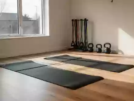 Ein heller, minimalistisch eingerichteter Physiotherapieraum mit Sportmatten und Trainingsgeräten auf einem Holzboden. - Foto: über boerse-global.de