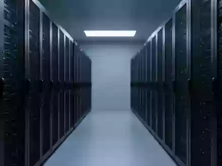 Reihen von schwarzen Server-Racks in einem minimalistischen, blau beleuchteten Rechenzentrum. - Foto: über boerse-global.de
