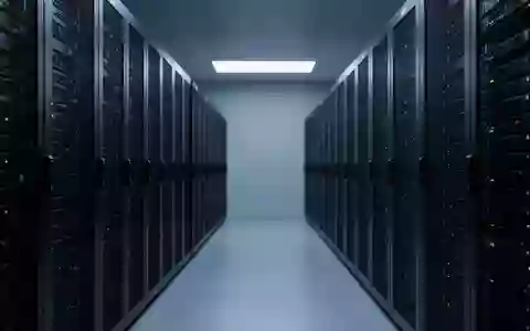 Reihen von schwarzen Server-Racks in einem minimalistischen, blau beleuchteten Rechenzentrum. - Foto: über boerse-global.de