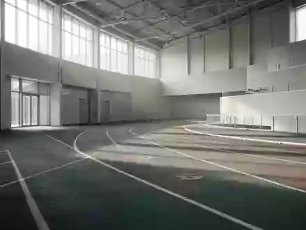 Leere, modern gestaltete Leichtathletikbahn in einer Sporthalle mit natürlichem Lichteinfall. - Foto: über boerse-global.de