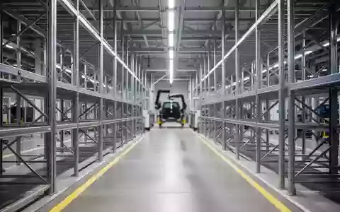 Moderne Montagehalle in einem Ingolstädter Automobilwerk mit industriellen Regalsystemen und markierten Bodenflächen. - Foto: über boerse-global.de