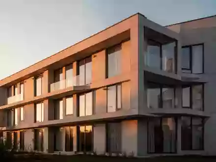 Moderne Wohnhausfassade bei Sonnenuntergang als Symbol für Mietverhältnisse und Wohnungswirtschaft. - Foto: über boerse-global.de