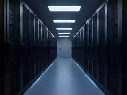Ein dunkler, modern beleuchteter Serverraum mit endlosen Reihen von Server-Racks in einer minimalistischen Architektur. - Foto: über boerse-global.de