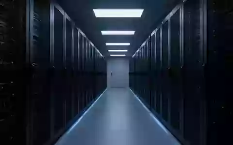 Ein dunkler, modern beleuchteter Serverraum mit endlosen Reihen von Server-Racks in einer minimalistischen Architektur. - Foto: über boerse-global.de