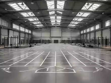 Eine weitlĂ€ufige, leere Industriehalle mit markierten Laufbahnen und Zonen fĂŒr funktionelles Training. - Foto: ĂŒber boerse-global.de