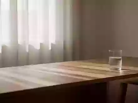 Ein minimalistischer Raum mit weichem Morgenlicht und einem Glas Wasser auf einem Holztisch, der eine ruhige Atmosphäre ausstrahlt. - Foto: über boerse-global.de