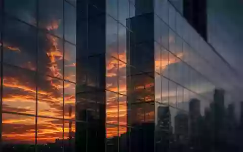 Moderne Glasfassade eines Bürogebäudes bei Sonnenuntergang als Symbol für den Finanzsektor. - Foto: über boerse-global.de
